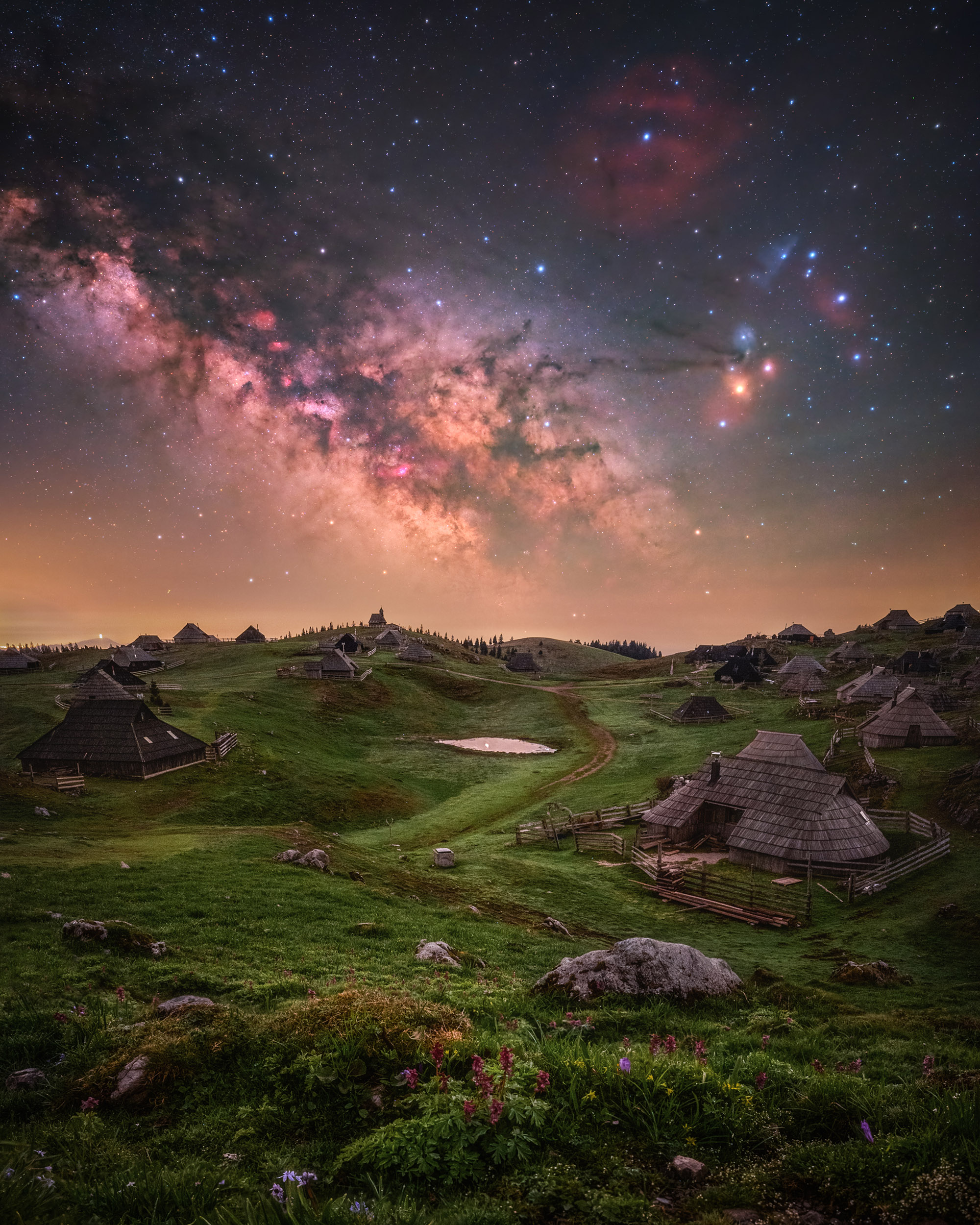 Velika Planina is one of the most beautiful places in Slovenia. In the foreground of this image, a settlement with the wooden huts characteristic of the area can be seen, while in the background the core of the Milky Way rises in all its beauty.